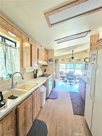 a large kitchen with a lot of cabinets stainless steel appliances and a large window