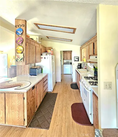 a large kitchen with stainless steel appliances granite countertop a lot of counter space and wooden floor