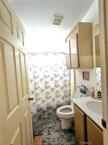 a bathroom with a granite countertop toilet a sink and a mirror