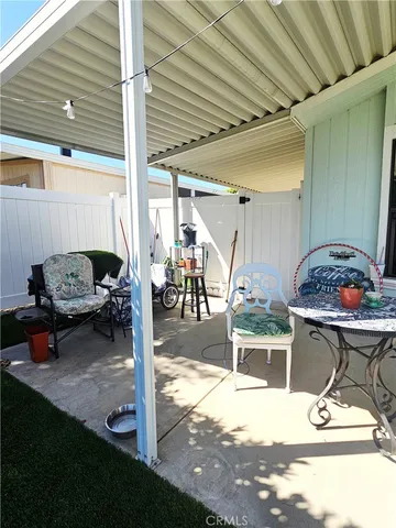 a view of a patio with couches table and chairs under an umbrella