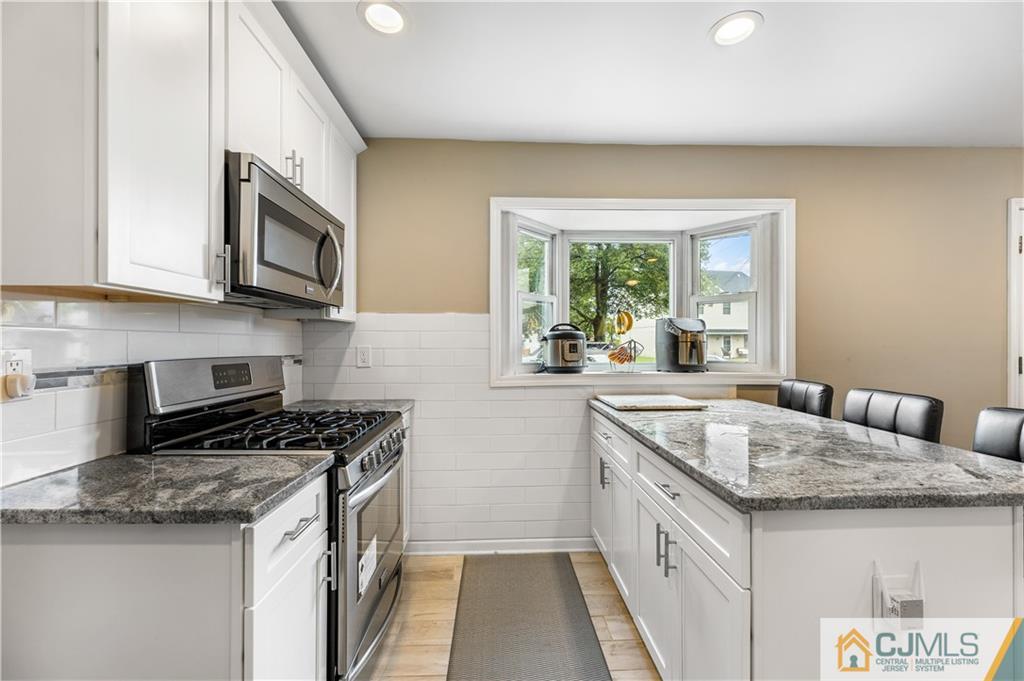 18 Baxter Road Edison, NJ 08817 - Photo 17 of 32 a kitchen with granite countertop a sink stove and cabinets