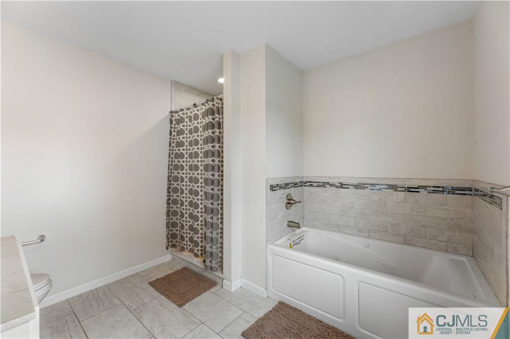 18 Baxter Road Edison, NJ 08817 - Photo 25 of 32 a bathroom with a bathtub and shower