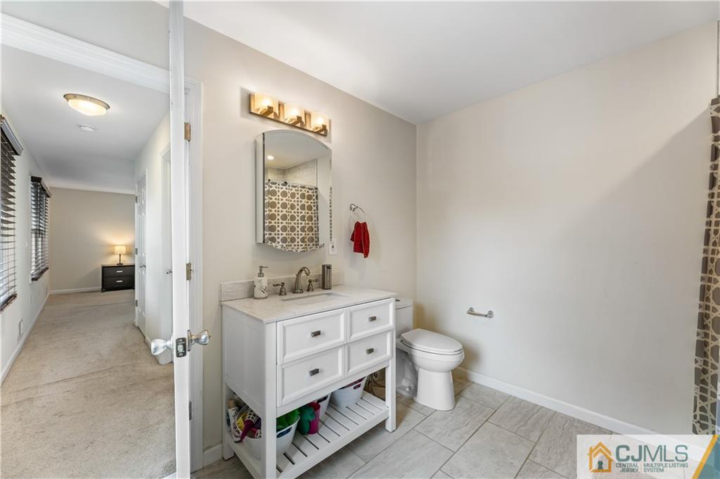 18 Baxter Road Edison, NJ 08817 - Photo 26 of 32 a bathroom with a toilet sink and mirror