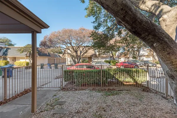 a view of a house with a small yard and a large tree