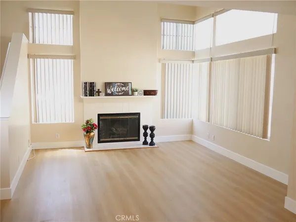 an empty room with windows and fireplace