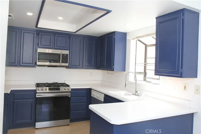a kitchen with granite countertop a sink a stove and microwave