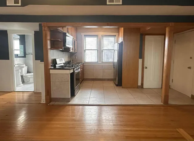 a kitchen with granite countertop a refrigerator and a stove top oven