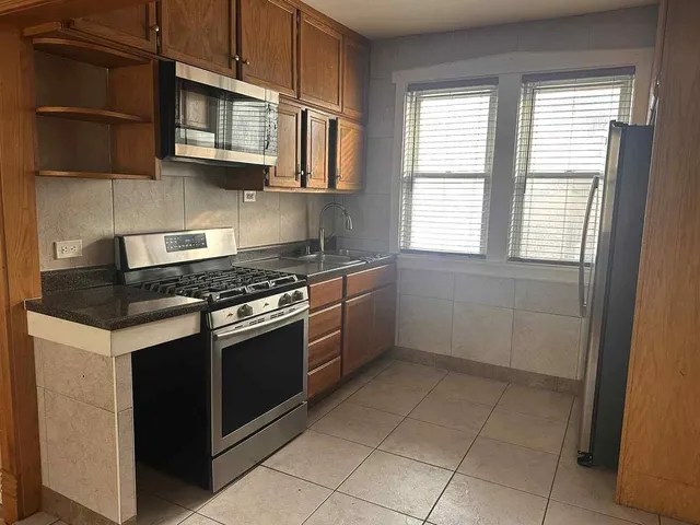 a kitchen with stainless steel appliances granite countertop a stove a sink and a microwave