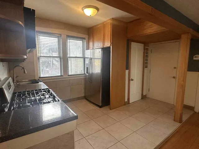 a view of kitchen with windows and refrigerator
