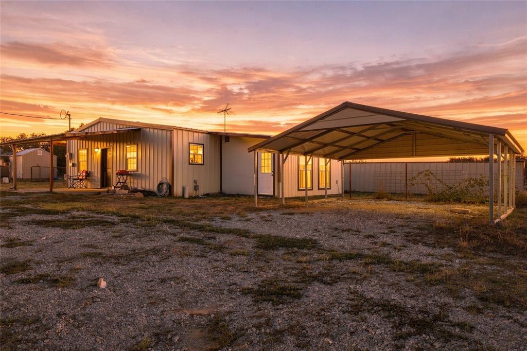 560 Green Acres Road Weatherford, TX 76088 - Photo 4 of 35 Second Home – Metal-sided structure with a covered porch, an attached carport, and a partially fenced perimeter