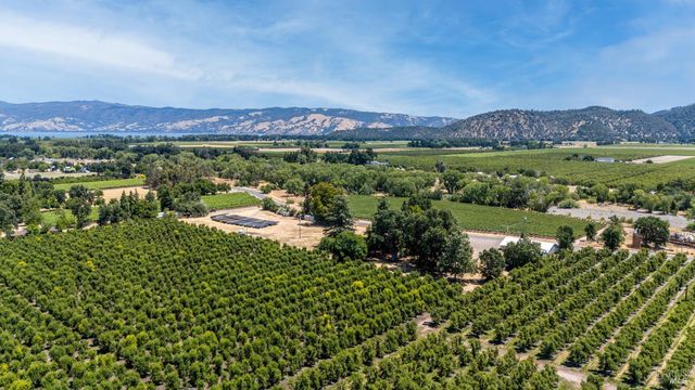 a view of a lush green field with mountains in the background