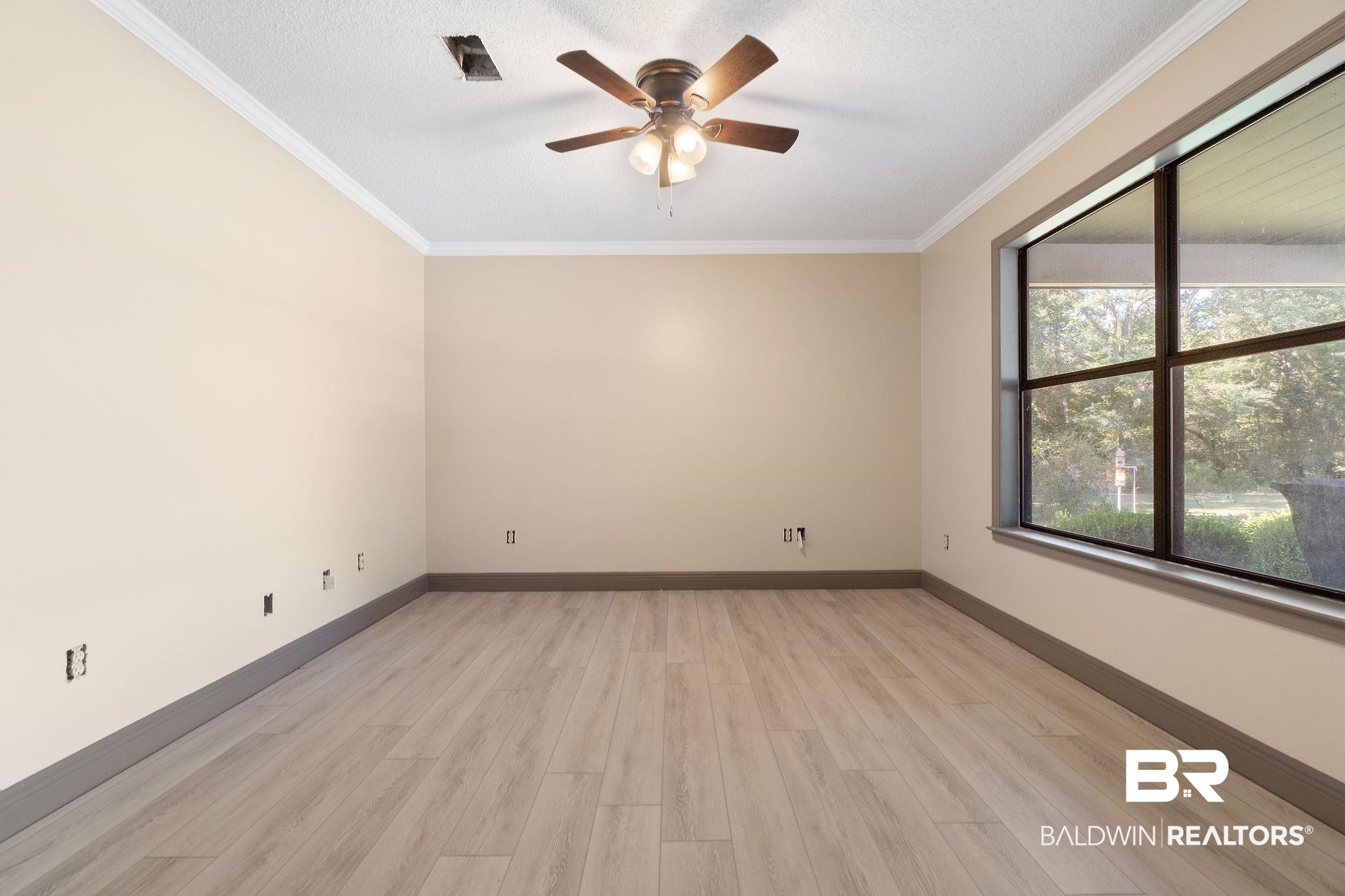 27300 C R Watson Road Robertsdale, AL 36567 - Photo 16 of 35 Spare room with light hardwood / wood-style floors, ornamental molding, a textured ceiling, and ceiling fan