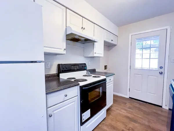 a kitchen with stainless steel appliances granite countertop a stove and a white cabinets