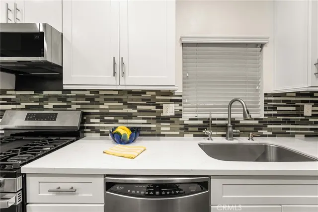 a kitchen with stainless steel appliances a stove a sink and a refrigerator