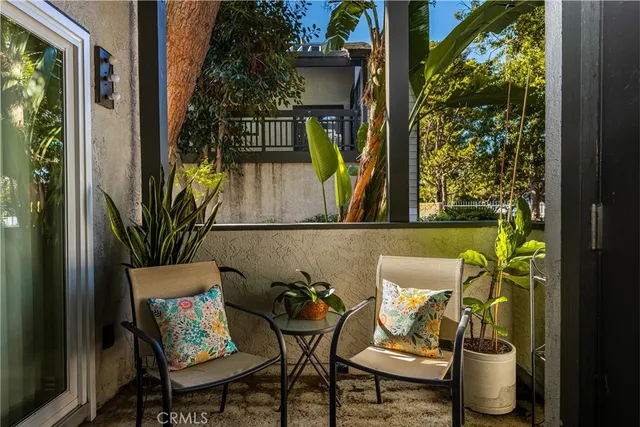 a view of a balcony with table and chairs and potted plants
