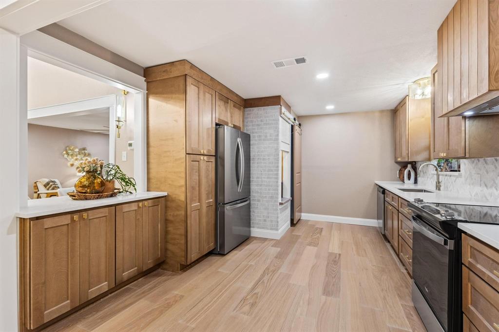 2214 Rex Cruse Drive Sherman, TX 75092 - Photo 17 of 40 a kitchen with stainless steel appliances a refrigerator and a sink
