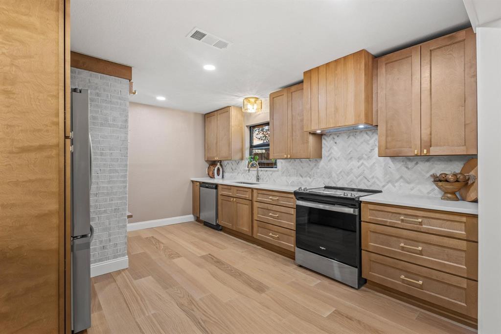 2214 Rex Cruse Drive Sherman, TX 75092 - Photo 18 of 40 a kitchen with stainless steel appliances granite countertop a stove a sink and a refrigerator