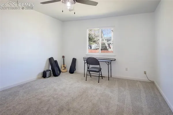 a view of a workspace with furniture and a window