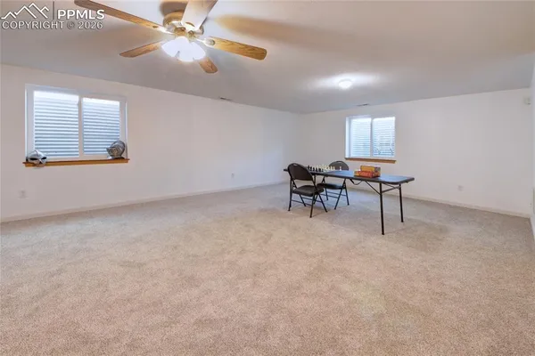 a view of a workspace with furniture and a window