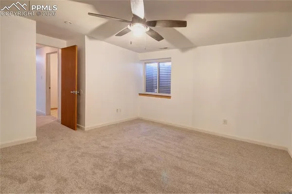 en empty room with windows and ceiling fan