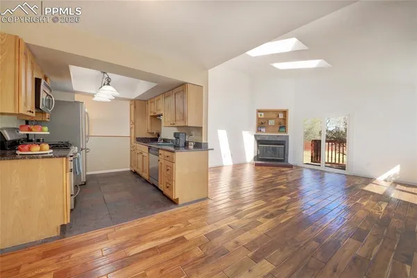 a kitchen with stainless steel appliances a refrigerator and wooden floor