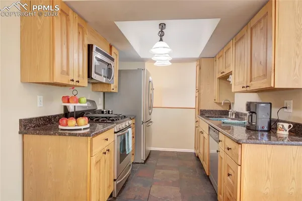 a kitchen with stainless steel appliances granite countertop a sink stove and cabinets