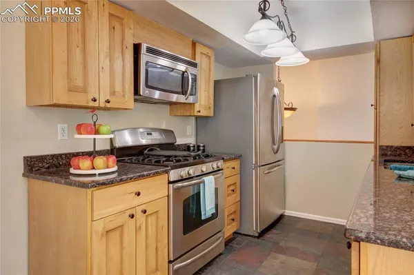 a kitchen with stainless steel appliances granite countertop a refrigerator and a stove
