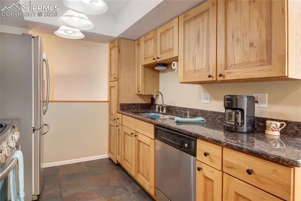 a kitchen with granite countertop cabinets stainless steel appliances and a counter space