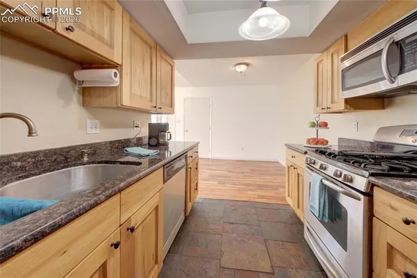 a kitchen with granite countertop a sink stainless steel appliances and cabinets