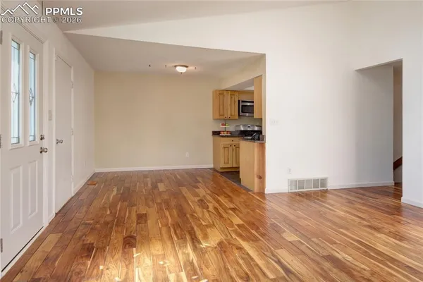 a view of empty room with wooden floor