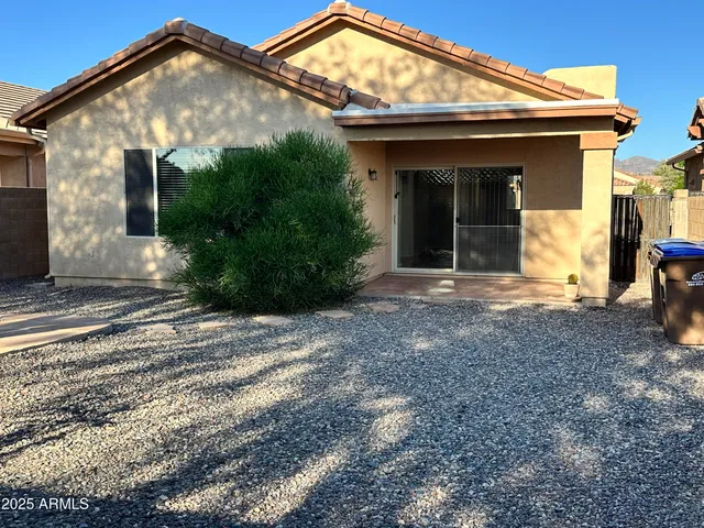 a backyard of a house with plants and outdoor seating