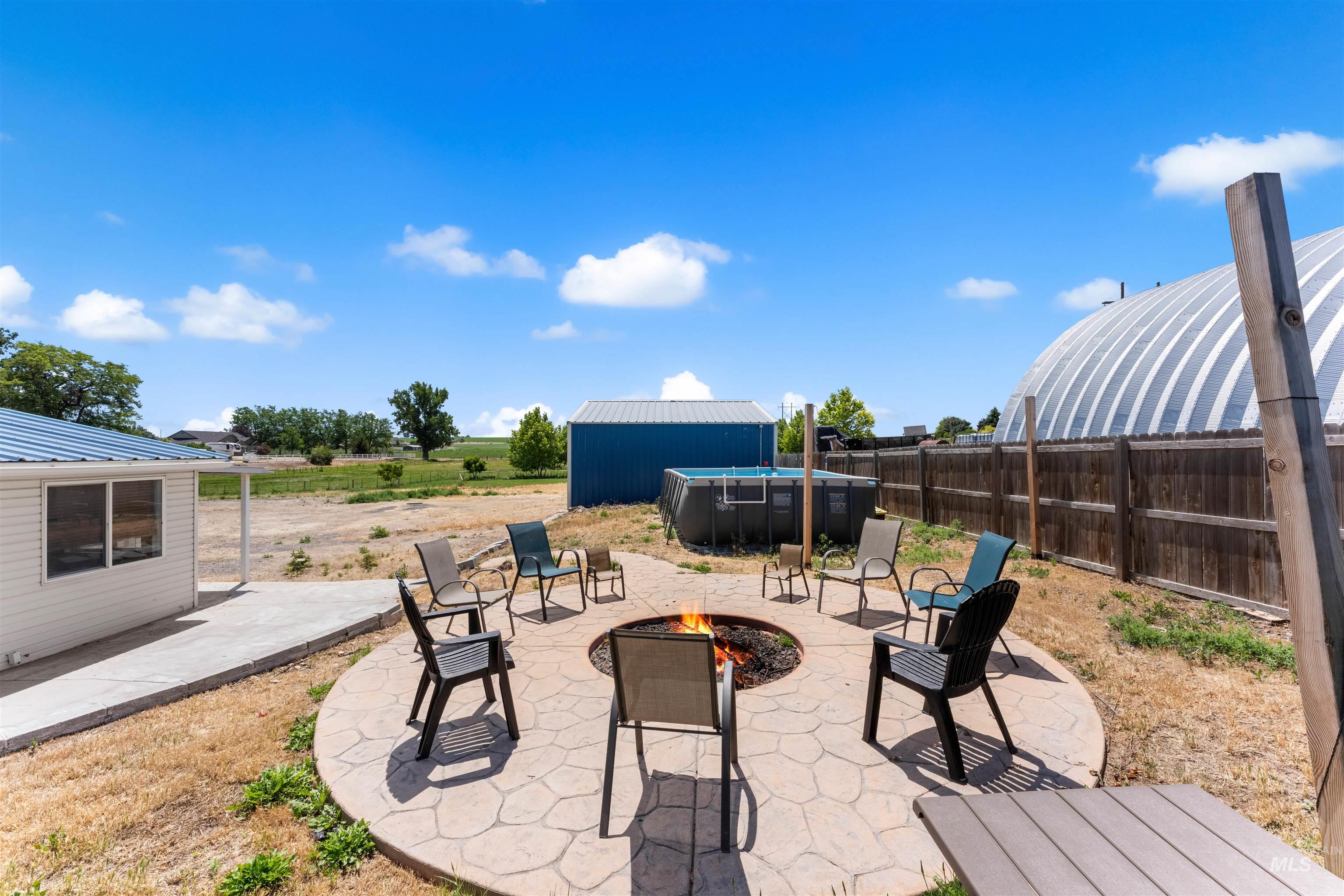17441 Upper Pleasant Ridge Road Caldwell, ID 83607 - Photo 33 of 40 Outdoor entertaining area with a stamped concrete patio, fire pit, and privacy fencing