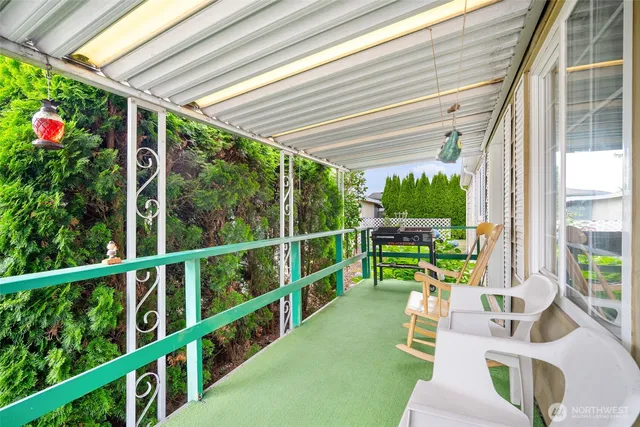 a porch area with flowers in front of it