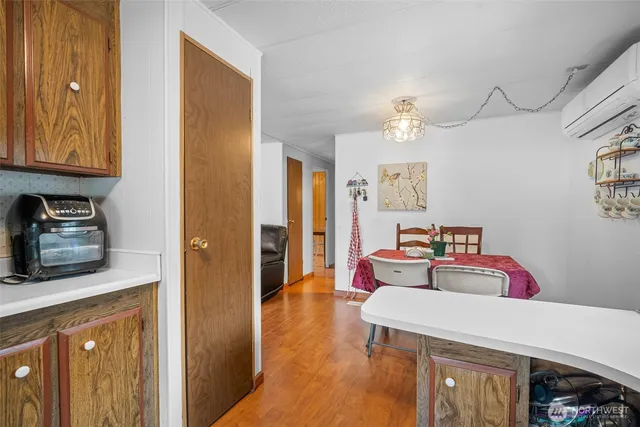 a hallway with a view of bedroom with a bed and wooden floor