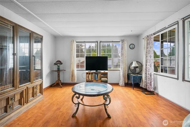 a living room with furniture a flat screen tv and a floor to ceiling window