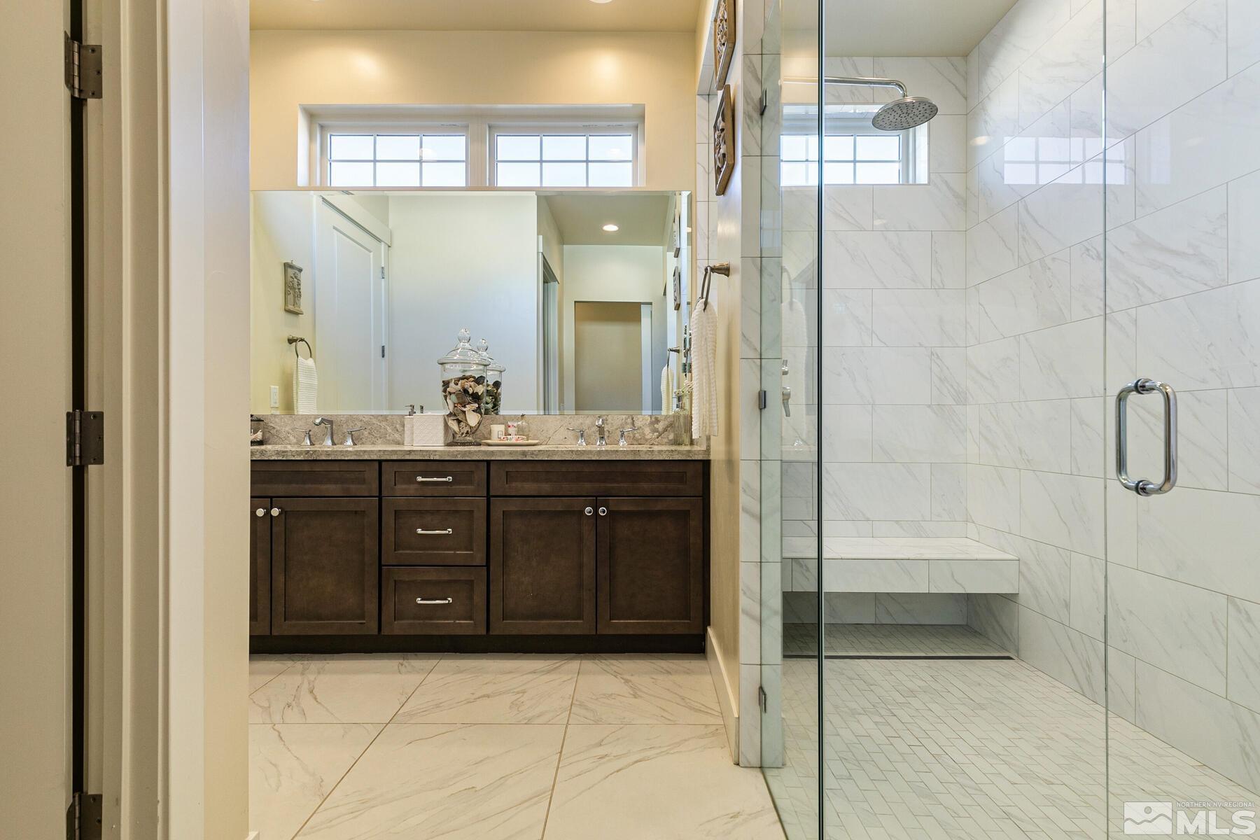 4104 Whispering Pine Loop Reno, NV 89519 - Photo 15 of 27 a bathroom with a granite countertop sink a mirror and a shower