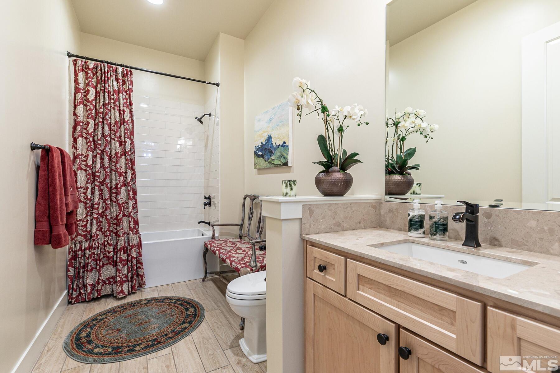 4104 Whispering Pine Loop Reno, NV 89519 - Photo 17 of 27 a bathroom with a sink a toilet and shower curtain