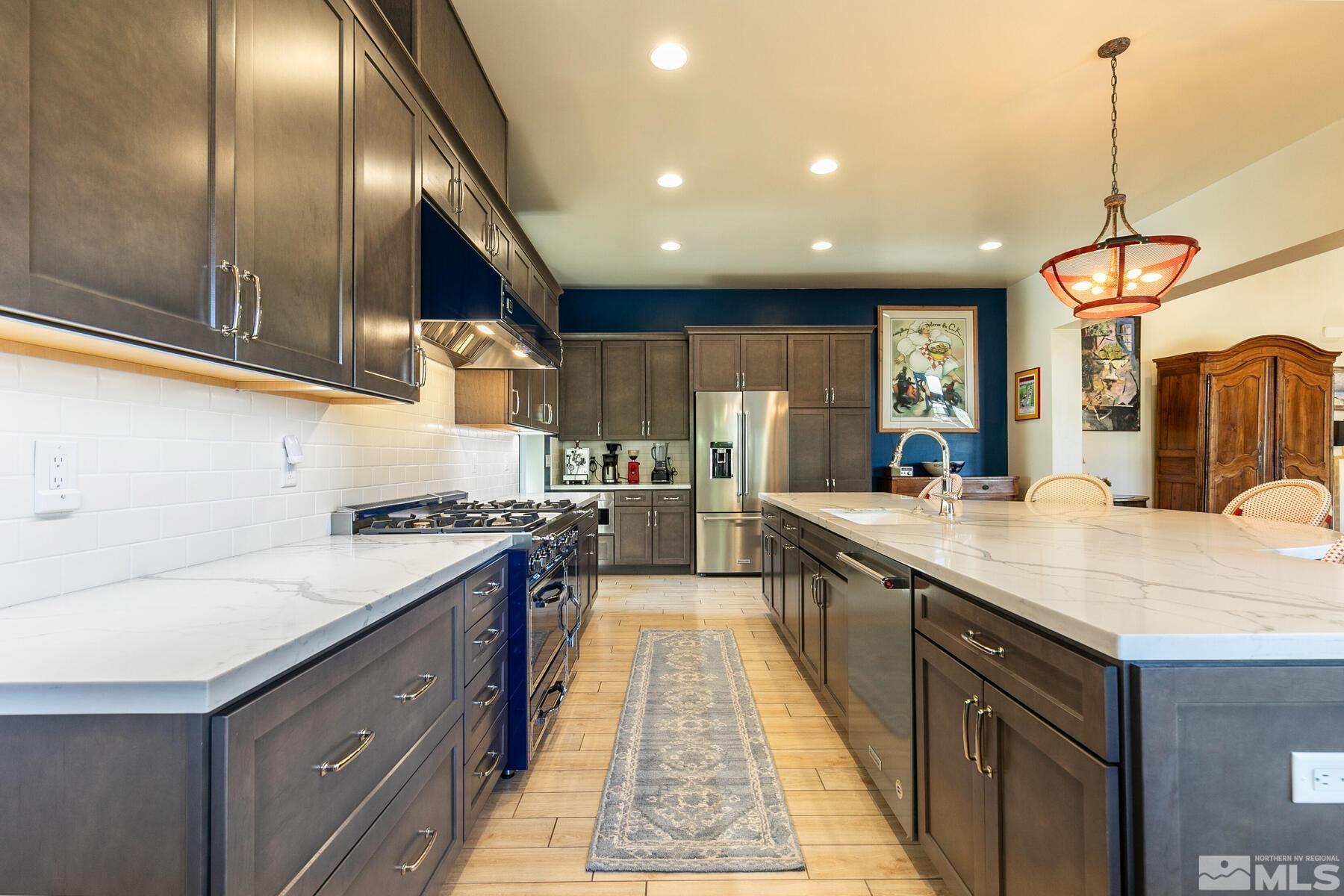 4104 Whispering Pine Loop Reno, NV 89519 - Photo 6 of 27 a kitchen with stainless steel appliances granite countertop a sink a stove and a wooden floors