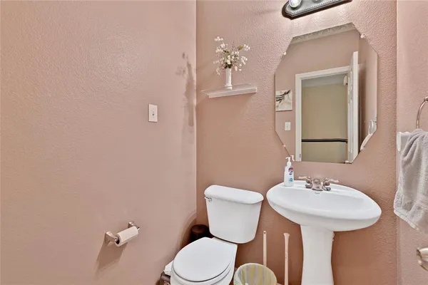 a bathroom with a toilet a sink and mirror
