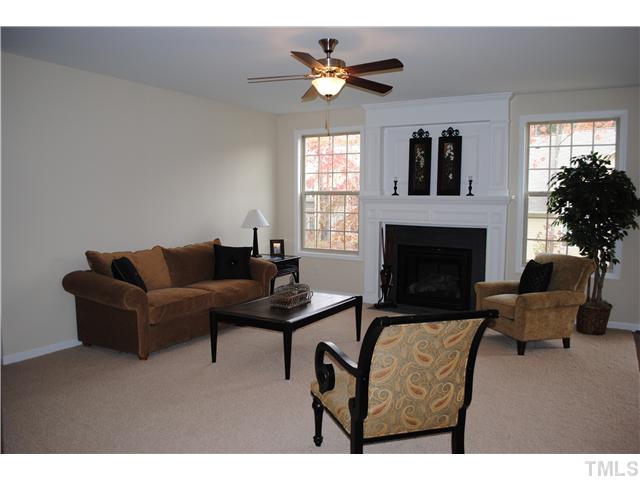 1009 Bianco Drive Raleigh, NC 27607 - Photo 4 of 12 a living room with furniture a fireplace and a large mirror