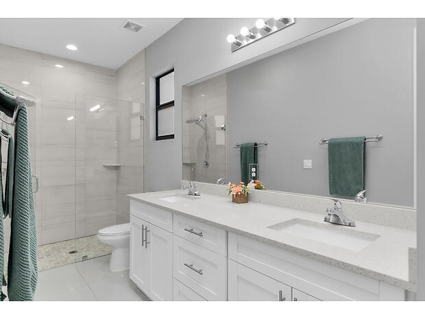 3625 54th Avenue Northeast Naples, FL 34120 - Photo 14 of 40 a bathroom with a double vanity sink toilet mirror and shower