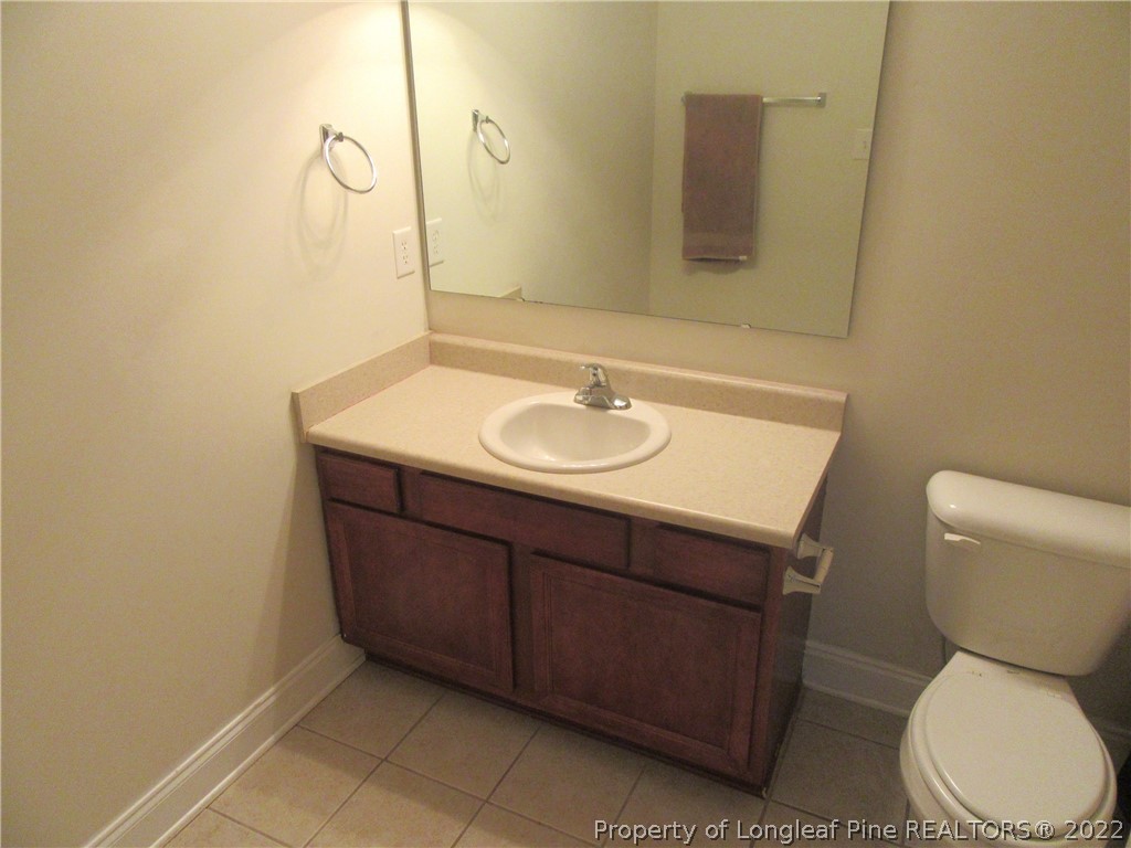 1615 Silver Ridge Court Fayetteville, NC 28304 - Photo 23 of 27 a bathroom with a toilet sink and mirror