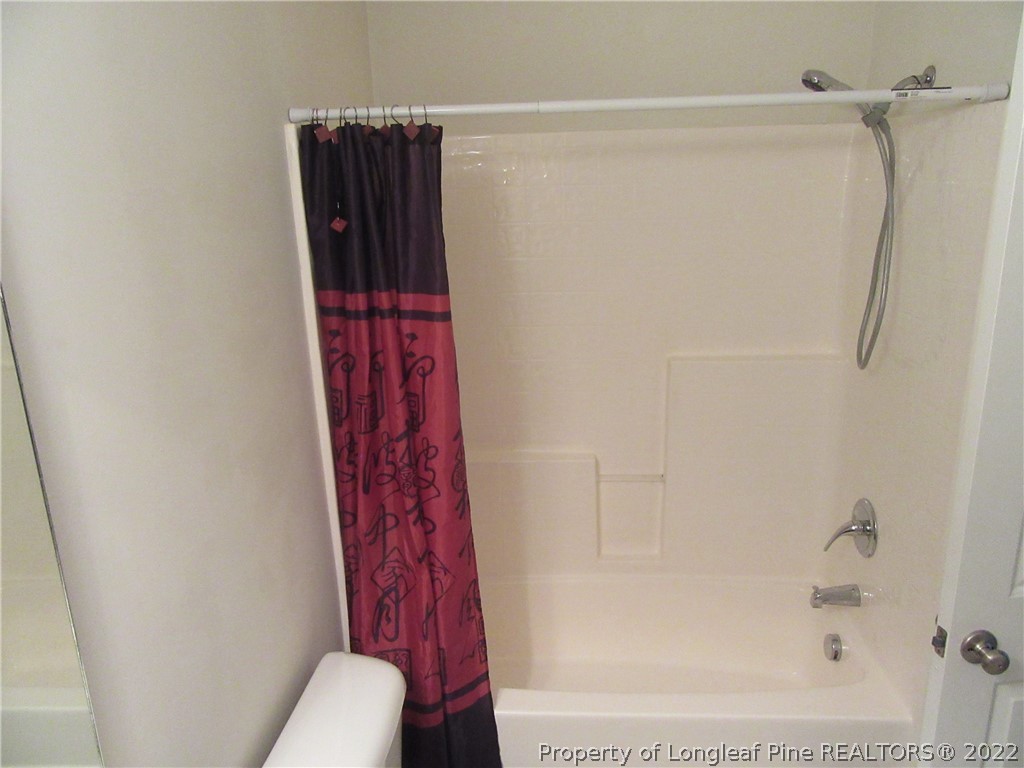 1615 Silver Ridge Court Fayetteville, NC 28304 - Photo 24 of 27 a bathroom with a shower curtain and a toilet