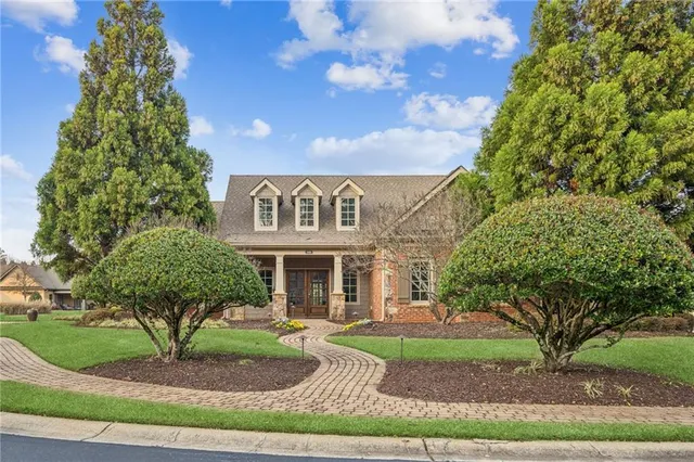 a view of a white house next to a yard