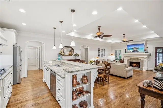 a very nice looking living room with a large window a fireplace and a chandelier