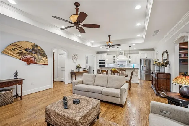 a living room with furniture kitchen view and a chandelier
