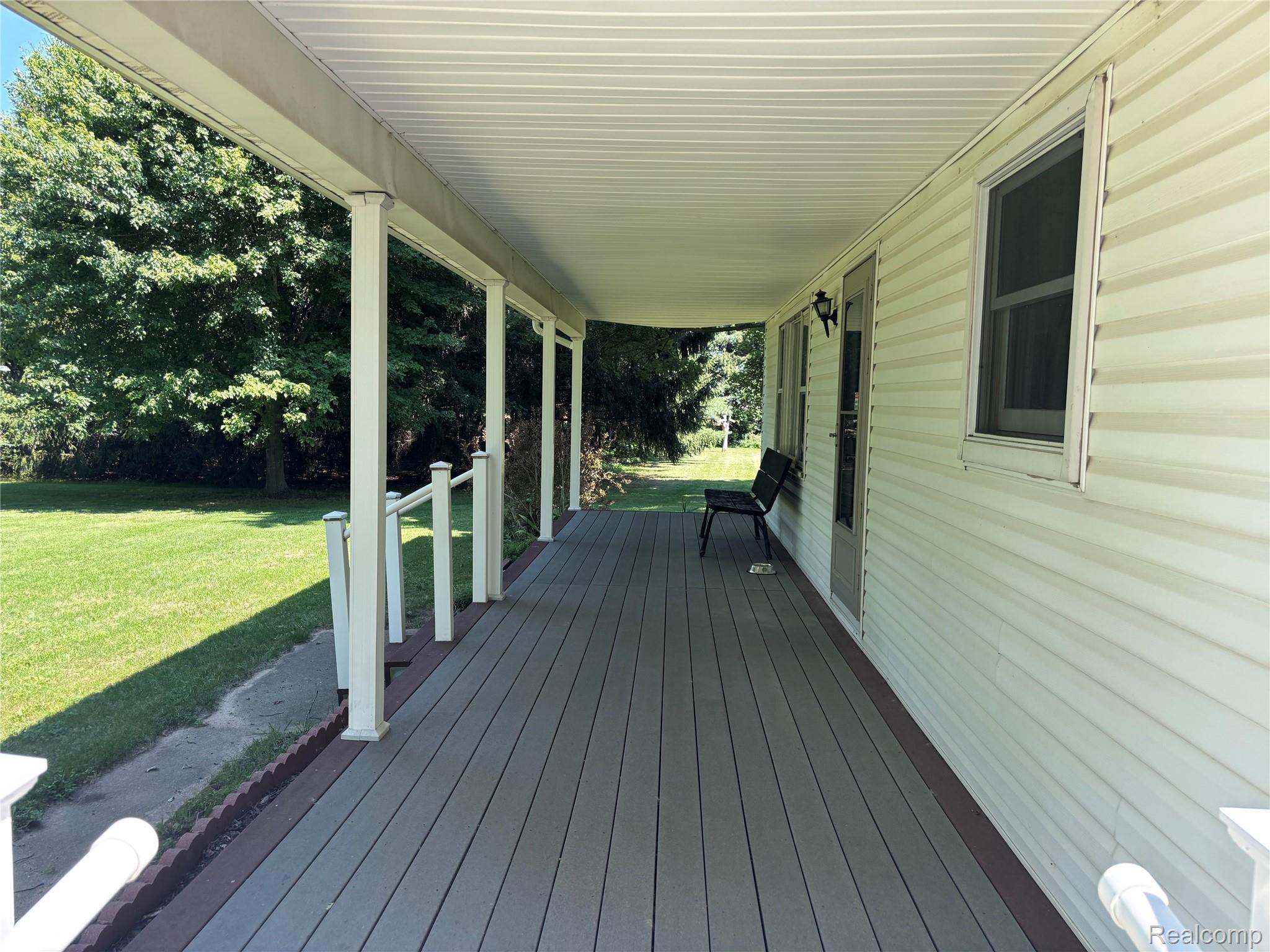 8531 South Waldron Road Pittsford, MI 49271 - Photo 3 of 40 Expansive covered porch featuring composite decking, white support columns, and white vinyl siding