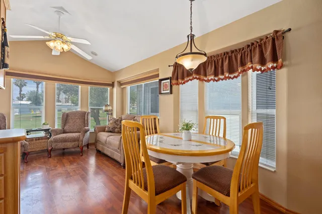 a dining room with furniture wooden floor a chandelier and a rug