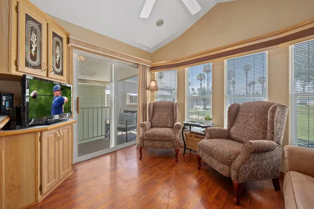 a living room with furniture tv and wooden floor