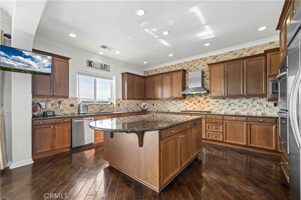 16423 Village Meadow Drive Riverside, CA 92503 - Photo 18 of 63 a kitchen with stainless steel appliances granite countertop wooden cabinets and a stove top oven